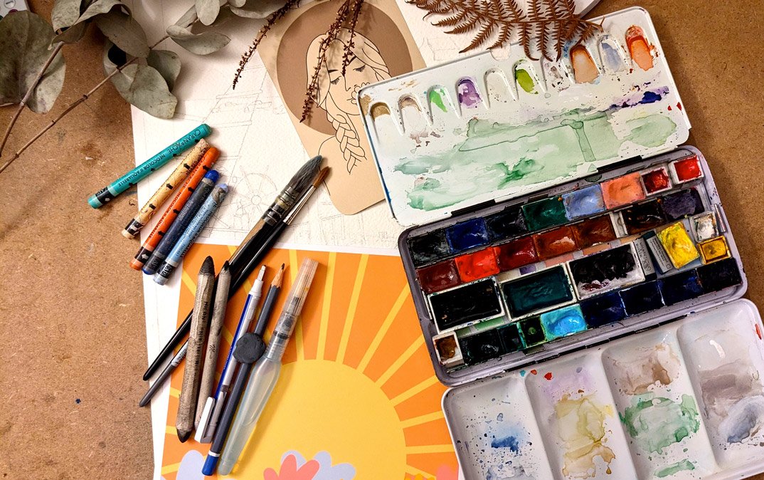 sur mon bureau mes aquarelles, des pastels gras et des illustrations